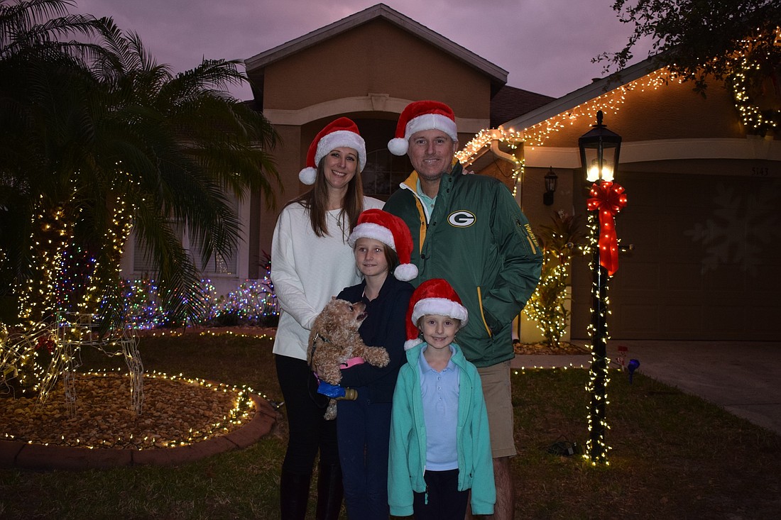 Lisa, Chris, Zofia and Bristol Scott enjoy the holiday decorations Florida Power and Light put on their home as a surprise for the family and a &#39;Thank you&#39; for Chris Scott&#39;s service in the Navy.