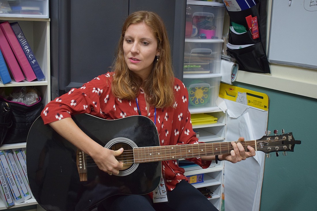 Abigail Hagan, an intern for Gulf Coast Music Therapy, sings a "Hello" song to a group of students.