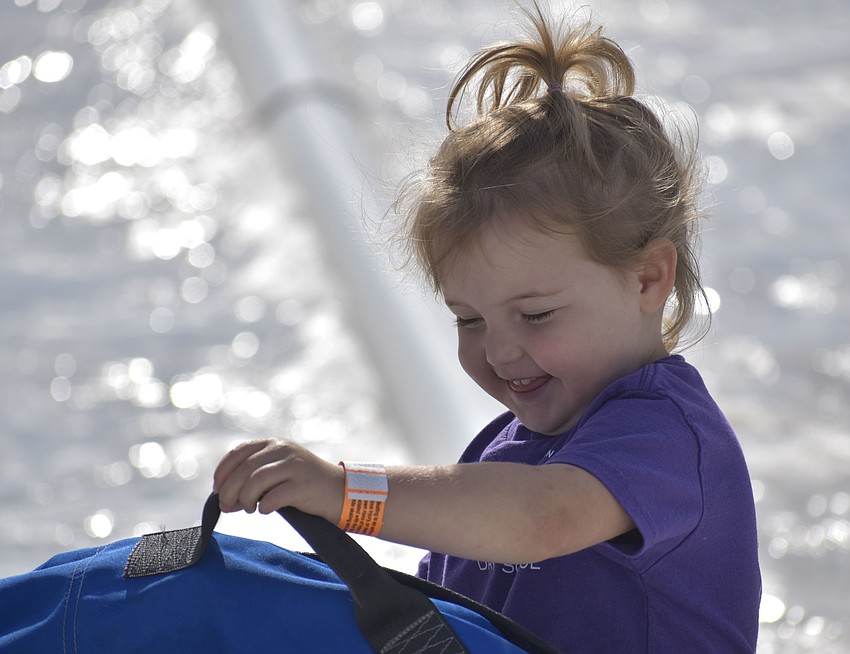 Tatum Horowitz, 3, picks up her tube after sliding down the hill.