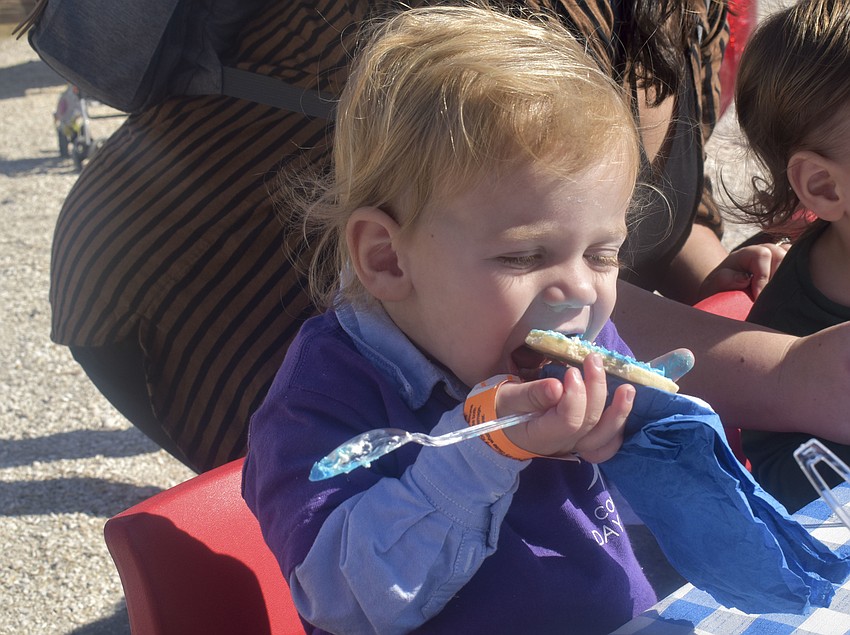 Sterling Saiger, 2, tastes the cookie he decorated.