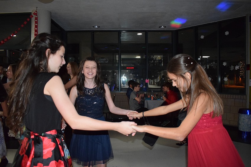 Emily Cappello, Elizabeth Graham and Elena Viteri, all sixth-graders, enjoy their first Snowcoming dance. Viteri said she loves singing, dancing and dressing up.