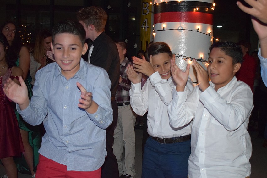 Sixth-graders Gabriel Baeza and Carlos Duque and eighth-grader Francisco Camquiz do the cha cha during the 