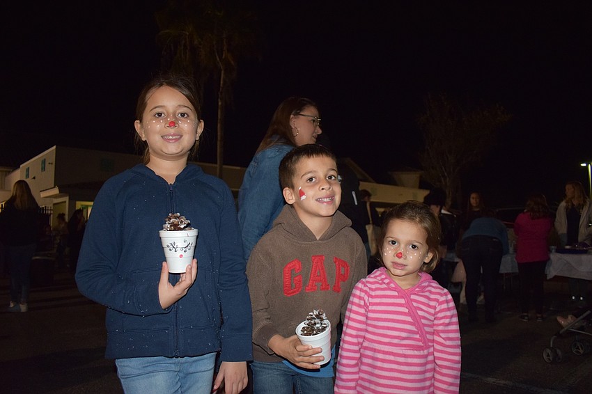 Wimauma residents Bella, Landen and Mila Mendoza show off their face paintings. Bella and Mila chose a reindeer design because they thought it was cute while Landen chose a Santa hat.