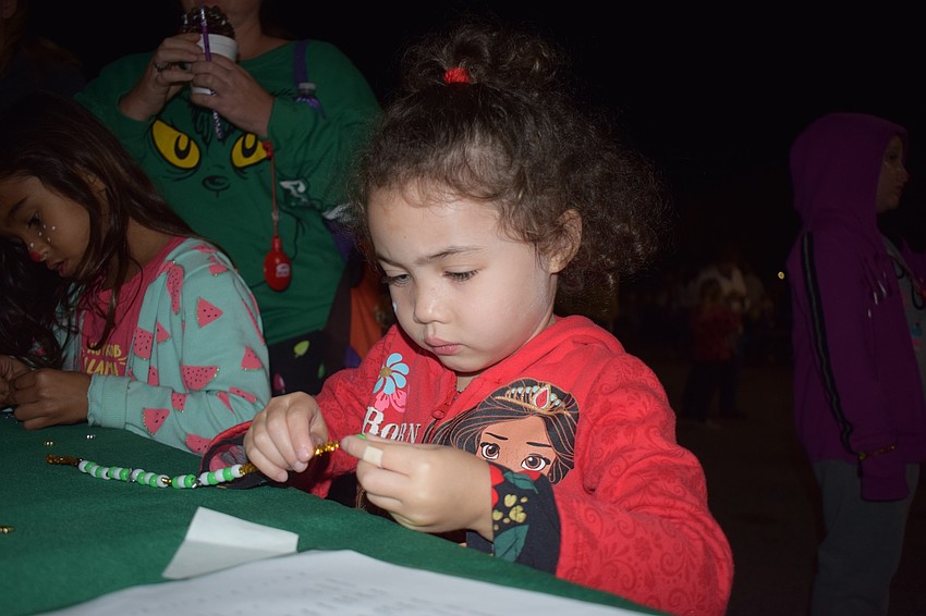 Palmetto's Aubree Washington, 4, makes a bracelet.
