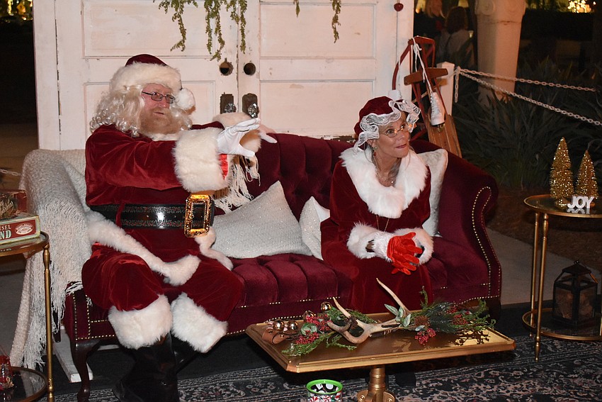 Santa and Mrs. Claus wave to the next child in line.