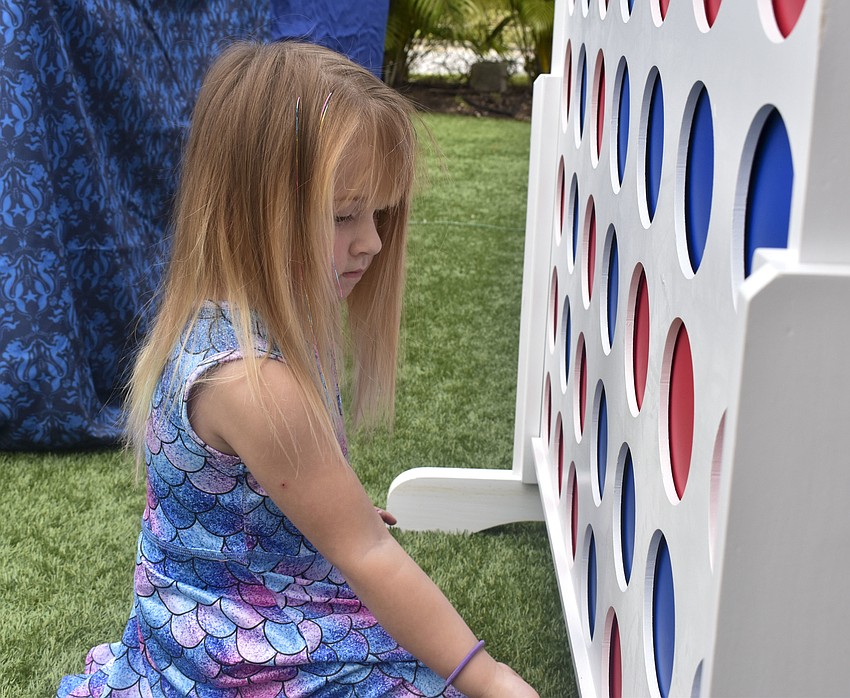 Lyllian Darlington, 3, plays giant Connect Four before the mermaid show.