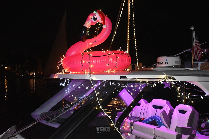 A flamingo adorned with lights graces one boat.