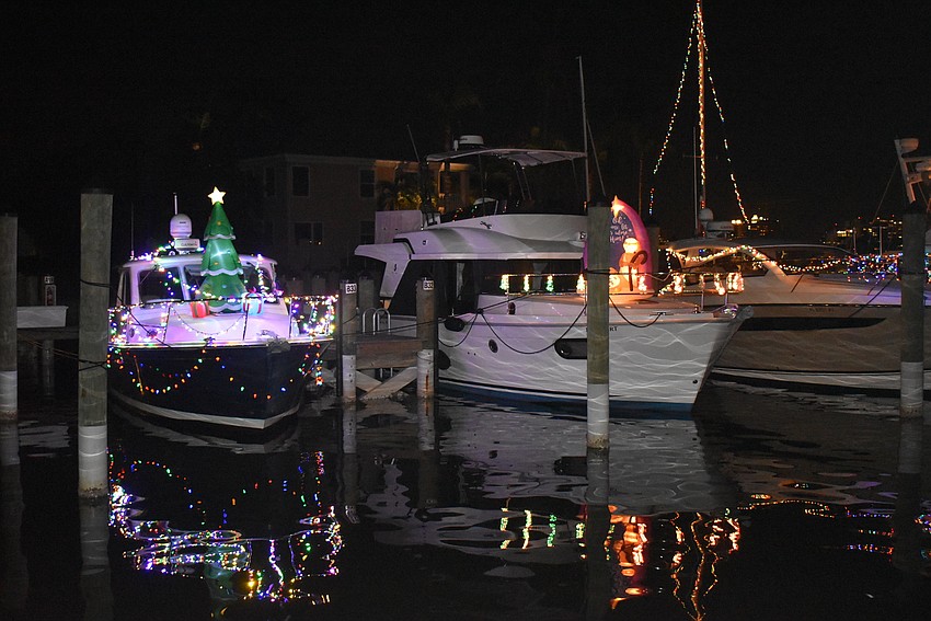 A lit-up Christmas tree atop one boat.
