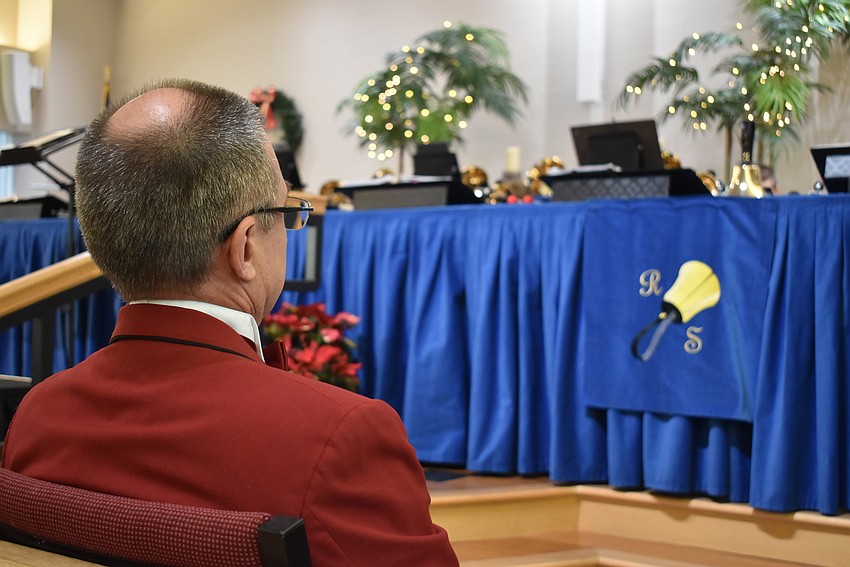 Conductor Rick Holdsworth watches as the brass musicians play.