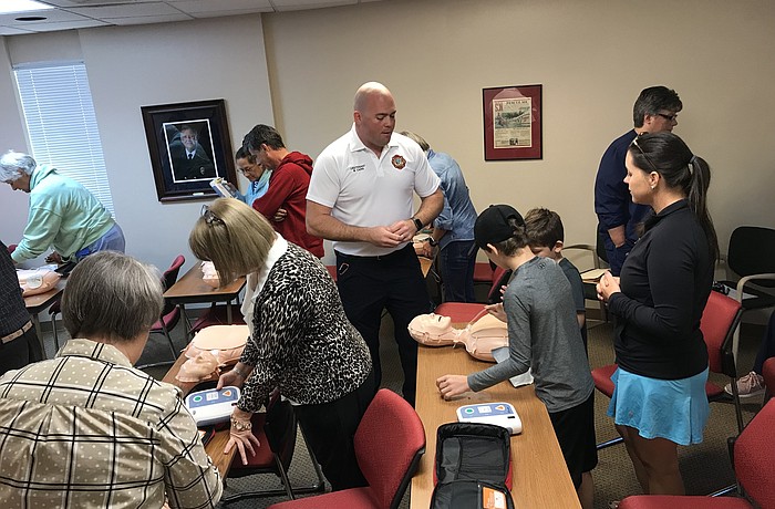Longboat Key Fire Rescue Department Lieutenant Bryan Carr watches over two boys as they practice CPR on a dummy. (Courtesy of the Longboat Key Fire Rescue Department)