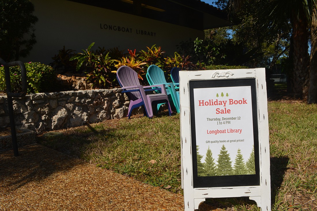 A sign advertising Longboat Library&#39;s holiday book sale sits outside the library.