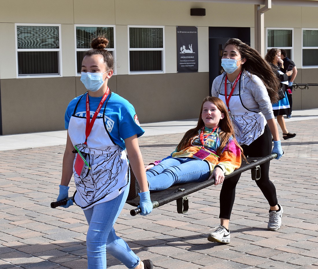 Haylee Hunderup and Yaritzel Ortega-Gomez carry Alannah Beausoleil to the morgue.