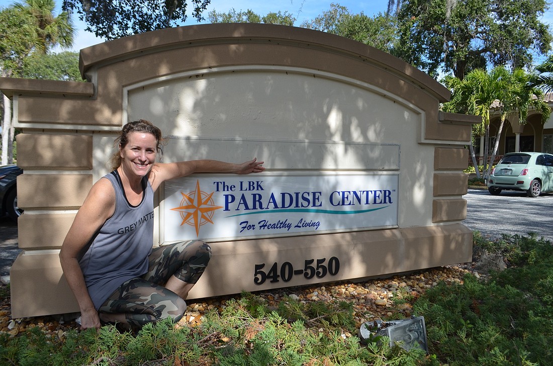 Suzy Brenner and her organization&#39;s new sign on Bay Isles Road.