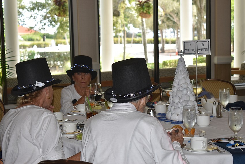 Three snowwomen eat together.