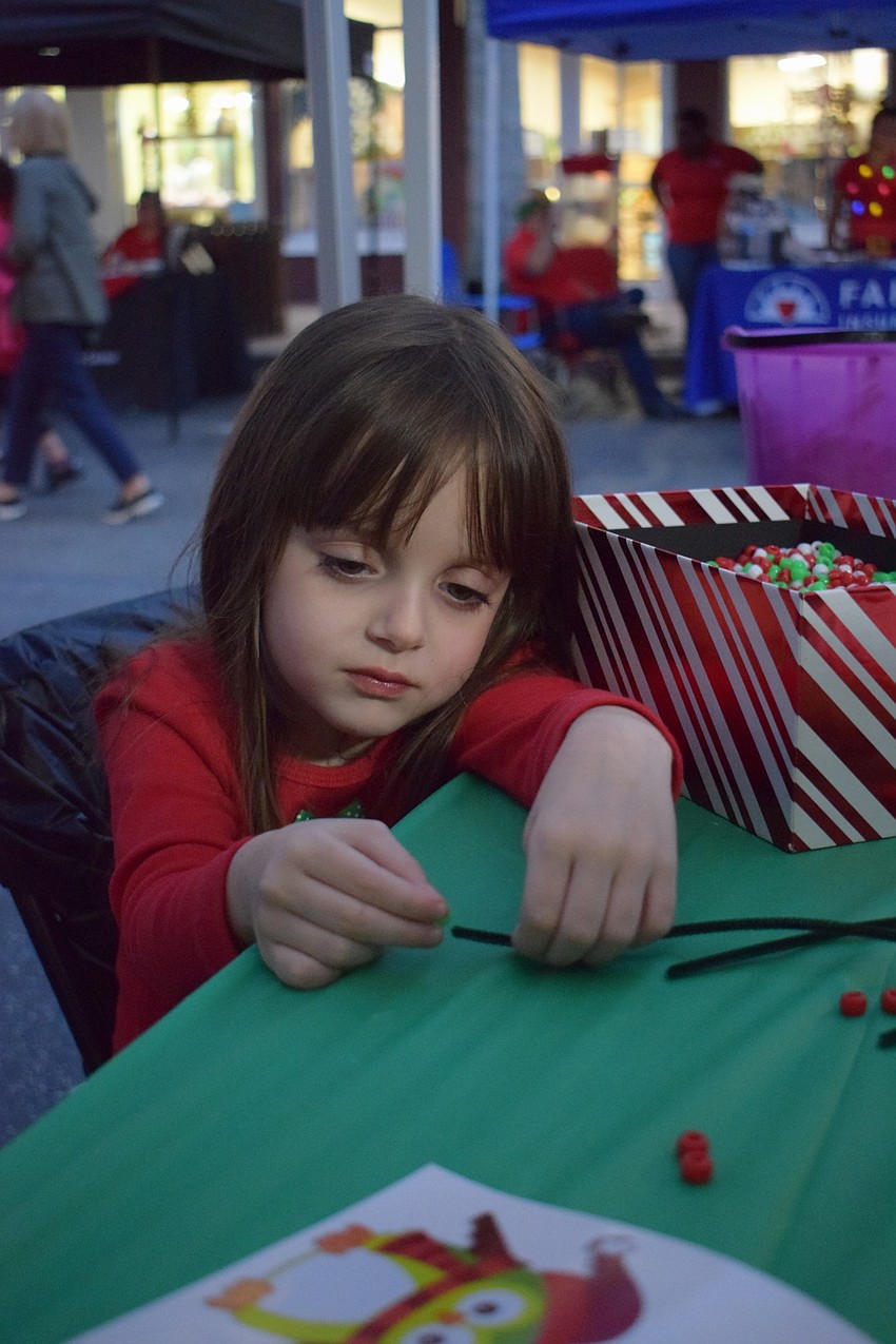 Longwood Run's Lilliana Mileto, 4, makes a bracelet with red, green and white beads.