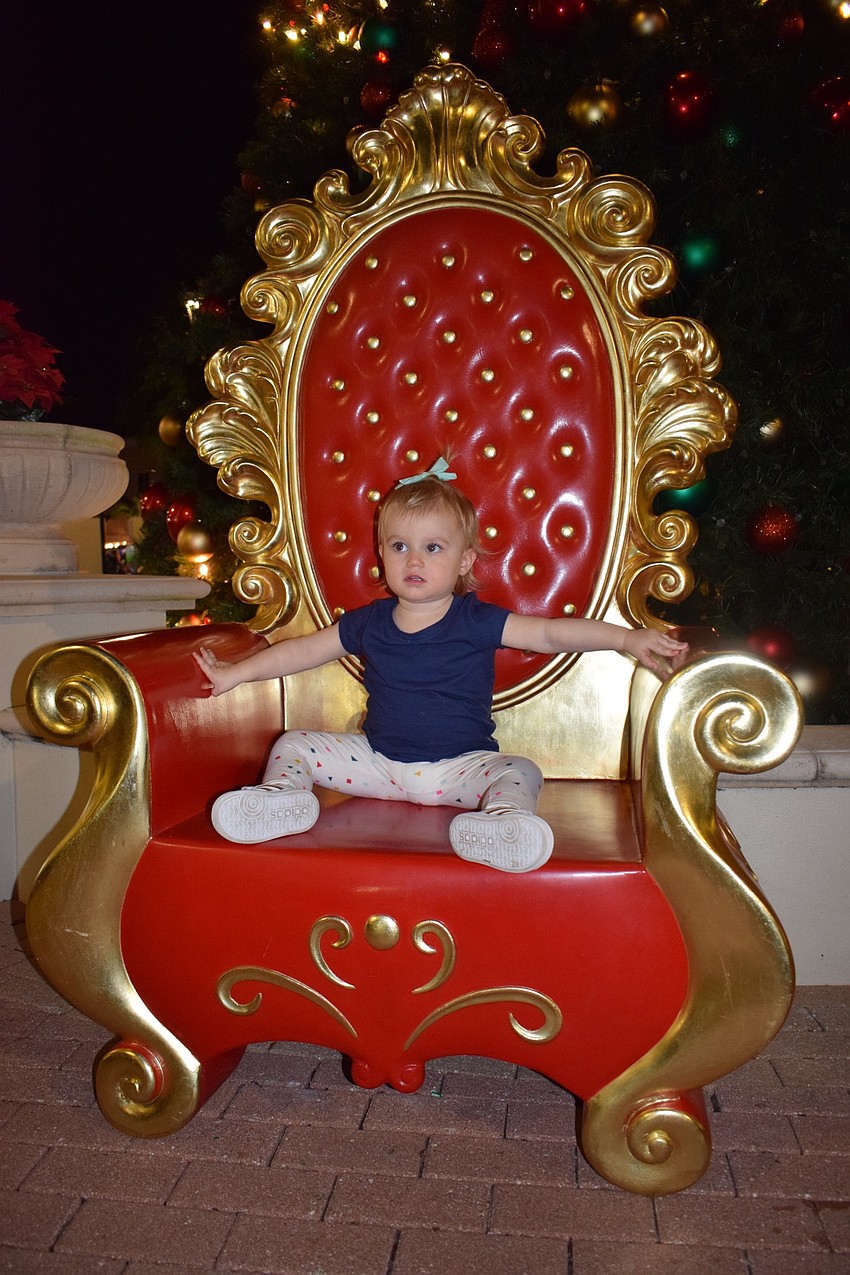 Lakewood Ranch's Harper Teague, 21 months, sits in Santa's big red chair as her parents, Krista and Matt, take photos of her to commemorate their first Christmas living in Lakewood Ranch.