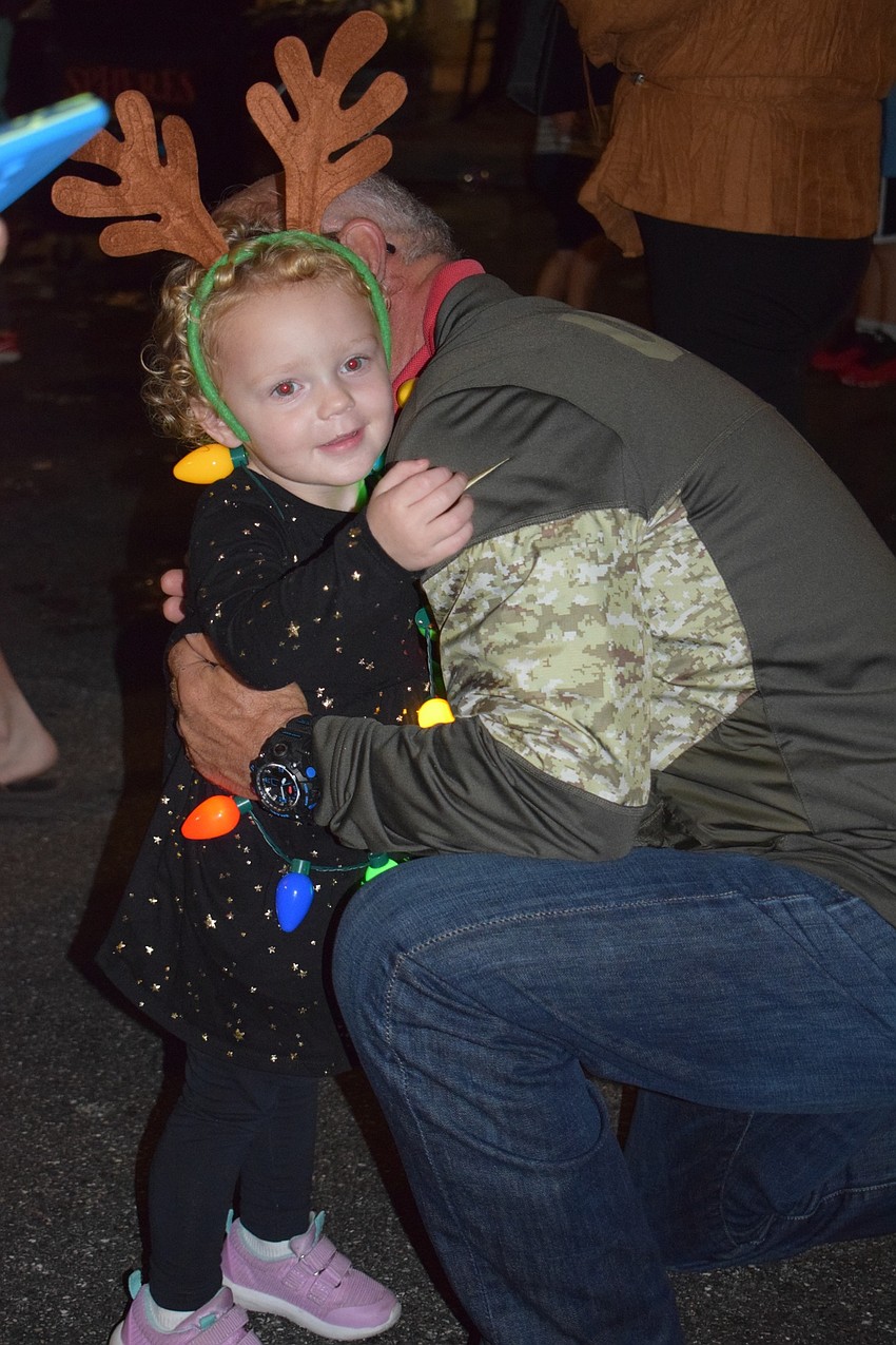 Sarasota's Steve Feix hugs his 2-year-old granddaughter, Lila Sharrer, of Lakewood Ranch before fixing her reindeer antlers.
