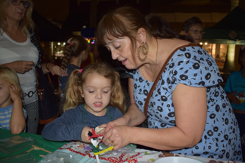 Alison Smith helps Paige Jessop, 5, make a holiday version of Forky from Disney Pixar's animated film 