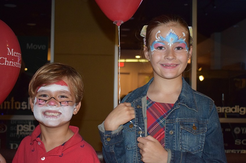 Lakewood Ranch's Michael, 5, and Madeline, 8, Pawlak get their faces painted. Michael chose Santa because he likes Santa, and Madeline chose a frozen princess because it has her favorite colors.