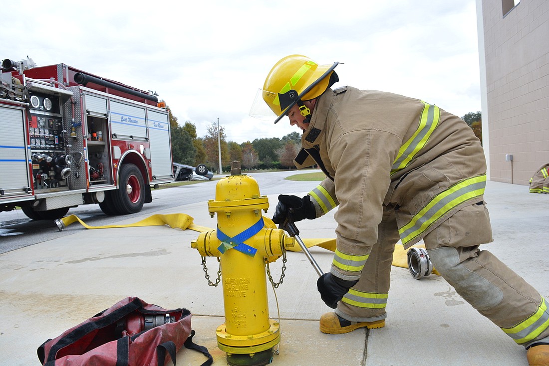 East Manatee Fire Rescue firefighter Larry Haymore connects a hose from the hydrant to a 1,000-gallon fire truck during a training exercise. He and other new hires will work at the district&#39;s new Station 7 on Covenant Way.