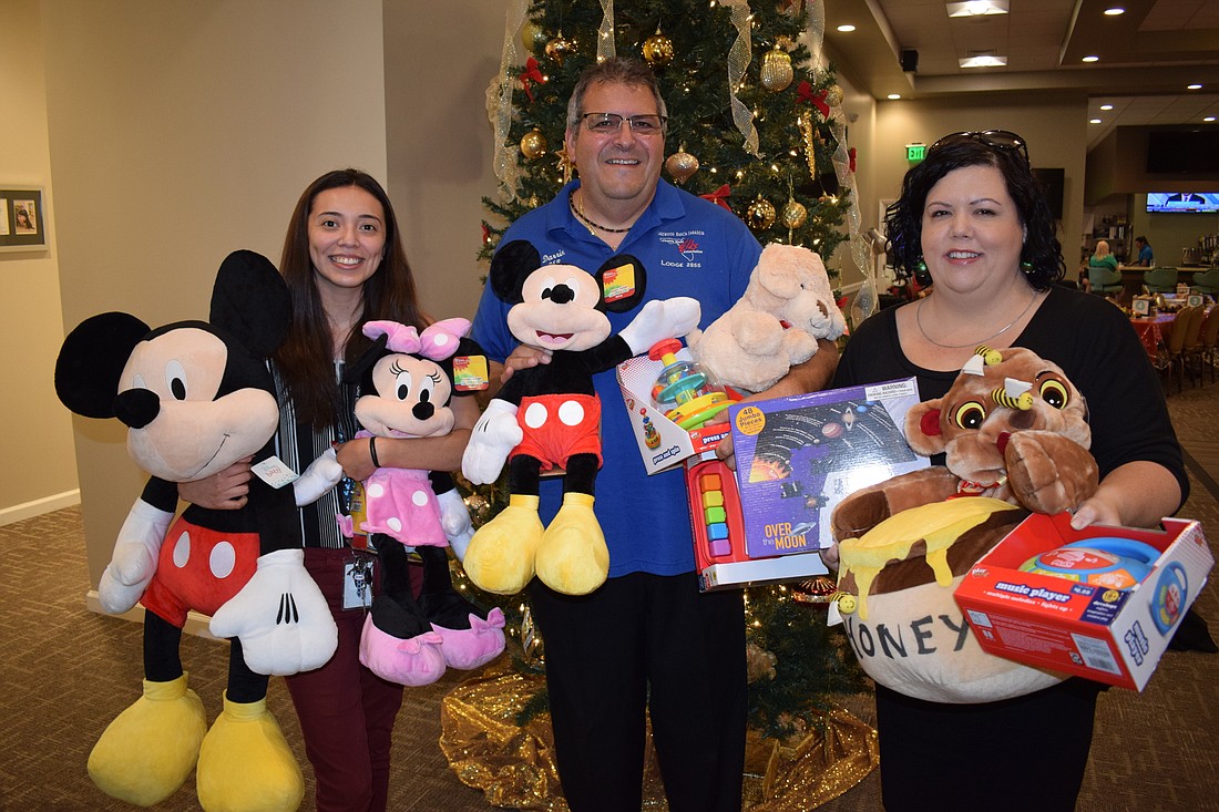 Hope Family Services&#39; Irene Martinez, the Lakewood Ranch Elks&#39; Darrin Simone and Hope&#39;s Lynn Lavigne go through toys the Elks collected for the nonprofit.