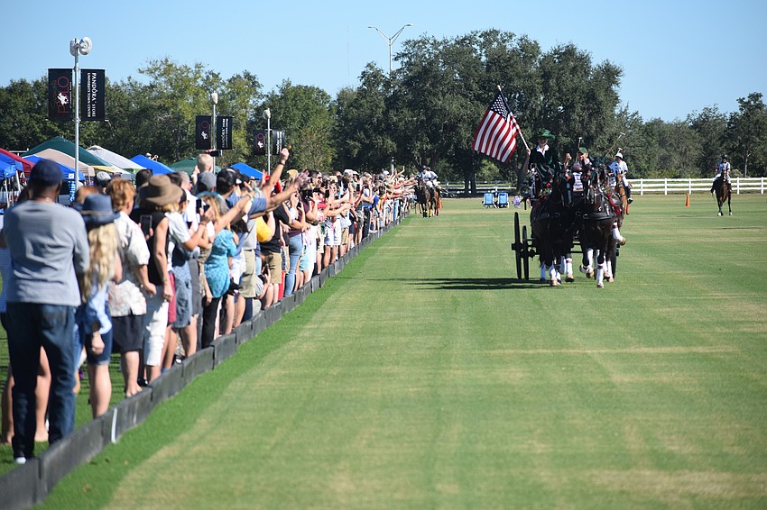 Sarasota Polo Club owner Misdee Miller and her team parades the American Flag past the fans before the game.