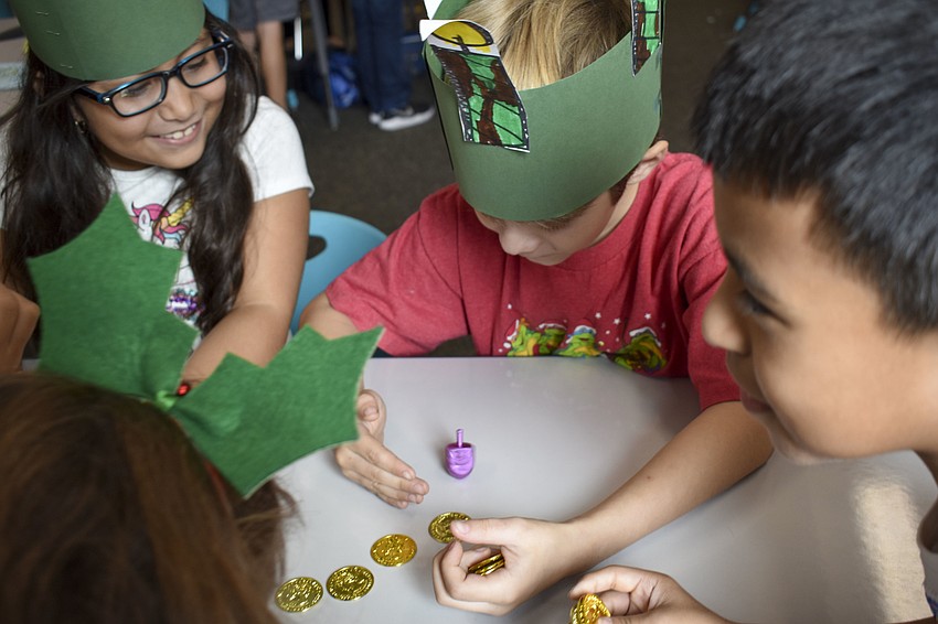 Jay J Bettis protects his dredel from his classmates as it spins.