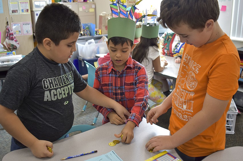 Yariel Hernandez, Yohan Aviles and Victor Crotinger pass out game coins.