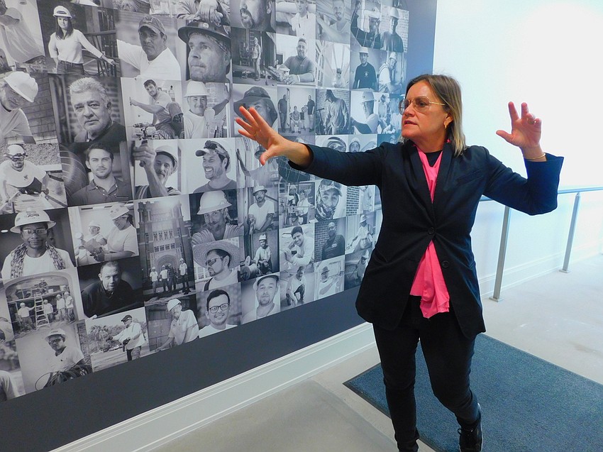 Sarasota Art Museum Executive Director Anne-Marie Russell describes the permanent photo installment of the workers who did the work on the museum's restoration.