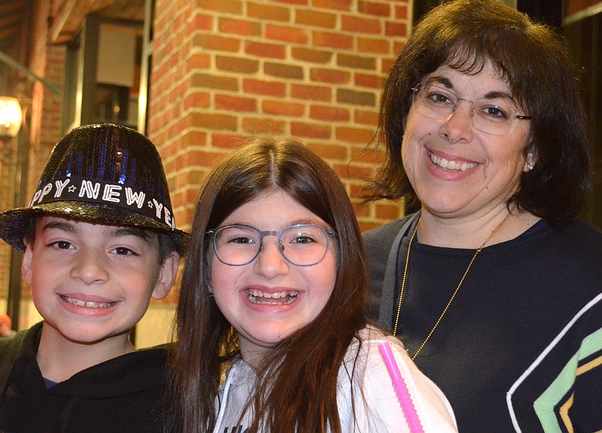 Ellis, Alex and Stephanie Israel were all smiles after winning a stuffed toy at a basketball-shooting game.