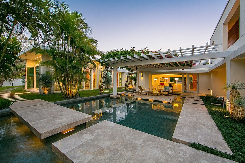 The outdoor oasis showcases a 40-foot lap pool complemented by serene waterfalls, fountains, two spas and a fire pit.