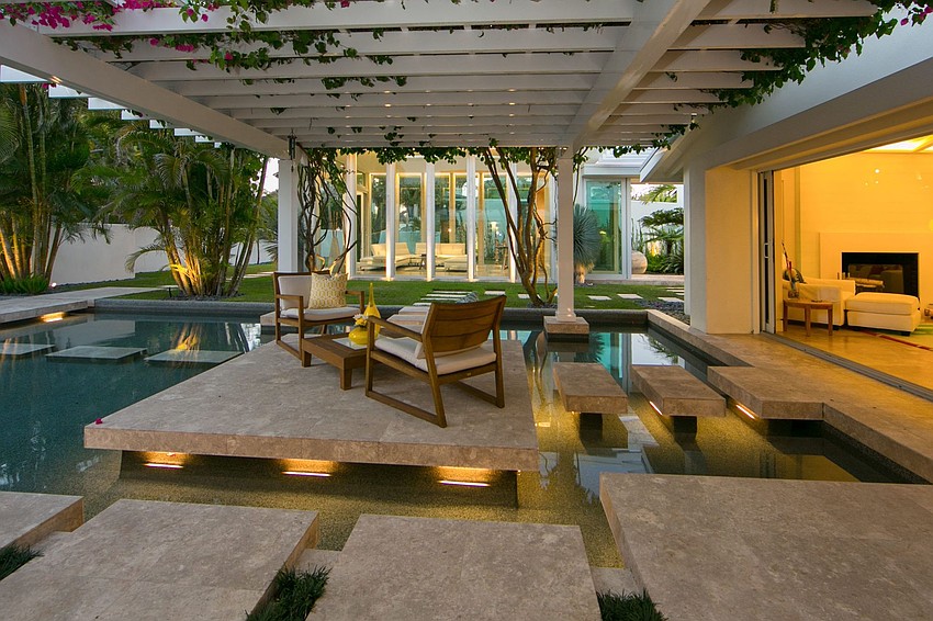 The outdoor oasis showcases a 40-foot lap pool complemented by serene waterfalls, fountains, two spas and a fire pit.