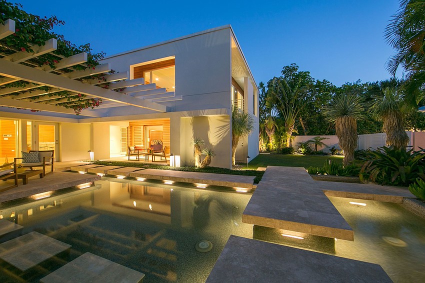 The outdoor oasis showcases a 40-foot lap pool complemented by serene waterfalls, fountains, two spas and a fire pit.