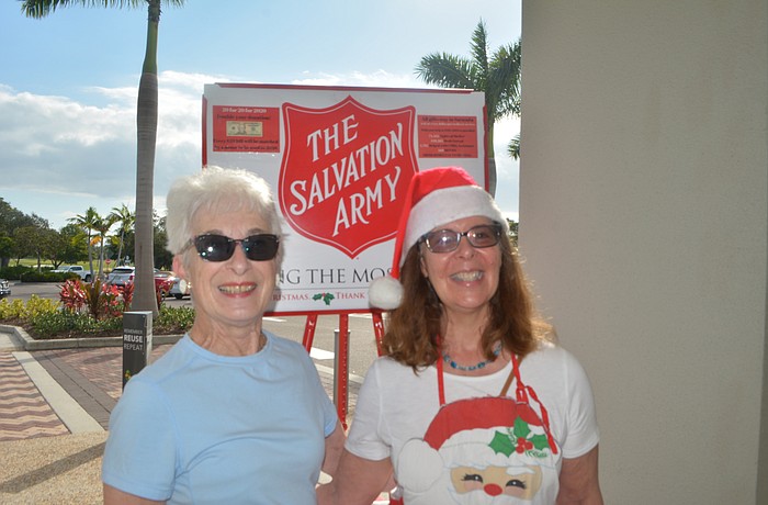Pat Bentley stands with volunteer Beth Fusco in front of the red kettle this season.