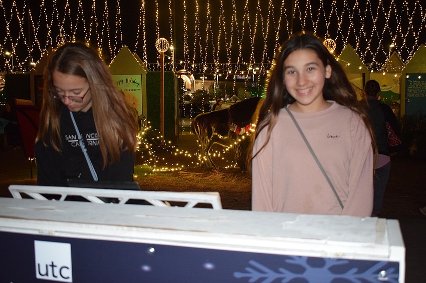 Lakewood Ranch's Kenzie Johnson and Kathryn Campbell play piano between activities. Johnson said she likes ice skating and riding bikes every year, and Campbell enjoys the horse carriages because 