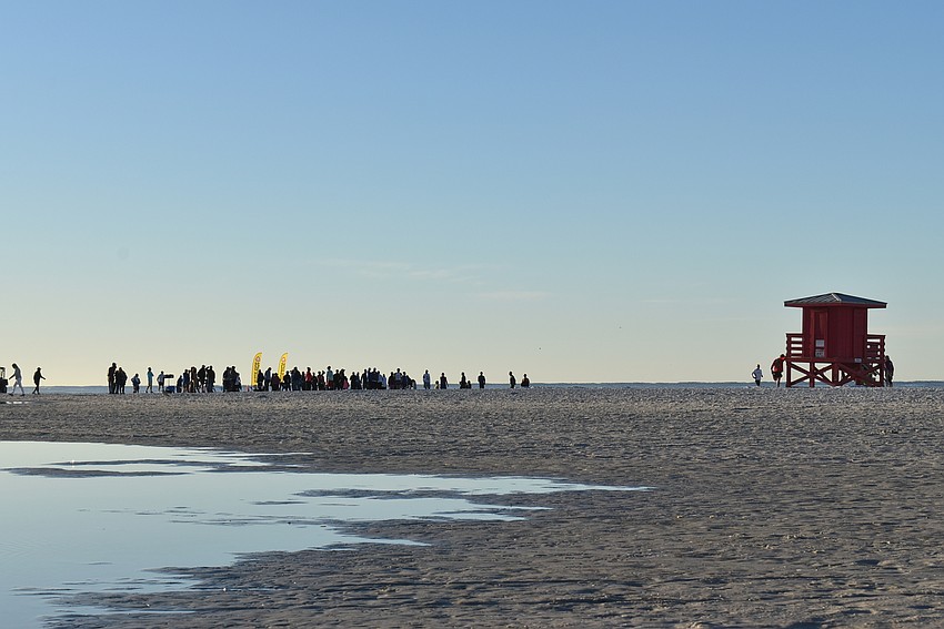 Runners line up near a lifeguard station.