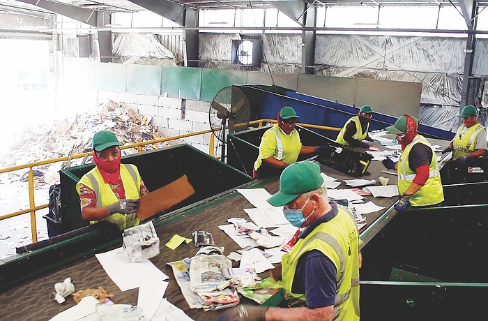 Employees separate recyclable and non recyclable materials.