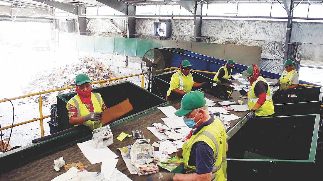Employees separate recyclable and non recyclable materials.