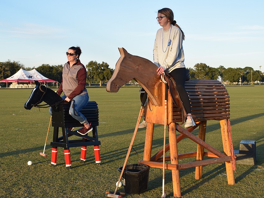 Lakewood Ranch's Tiffany Boyett and Rebecca Long mount wooden horses to play polo and take photos. The two moved to the area with Steve Boyett in July and went to Ranch Nite Wednesdays to get to know their community.
