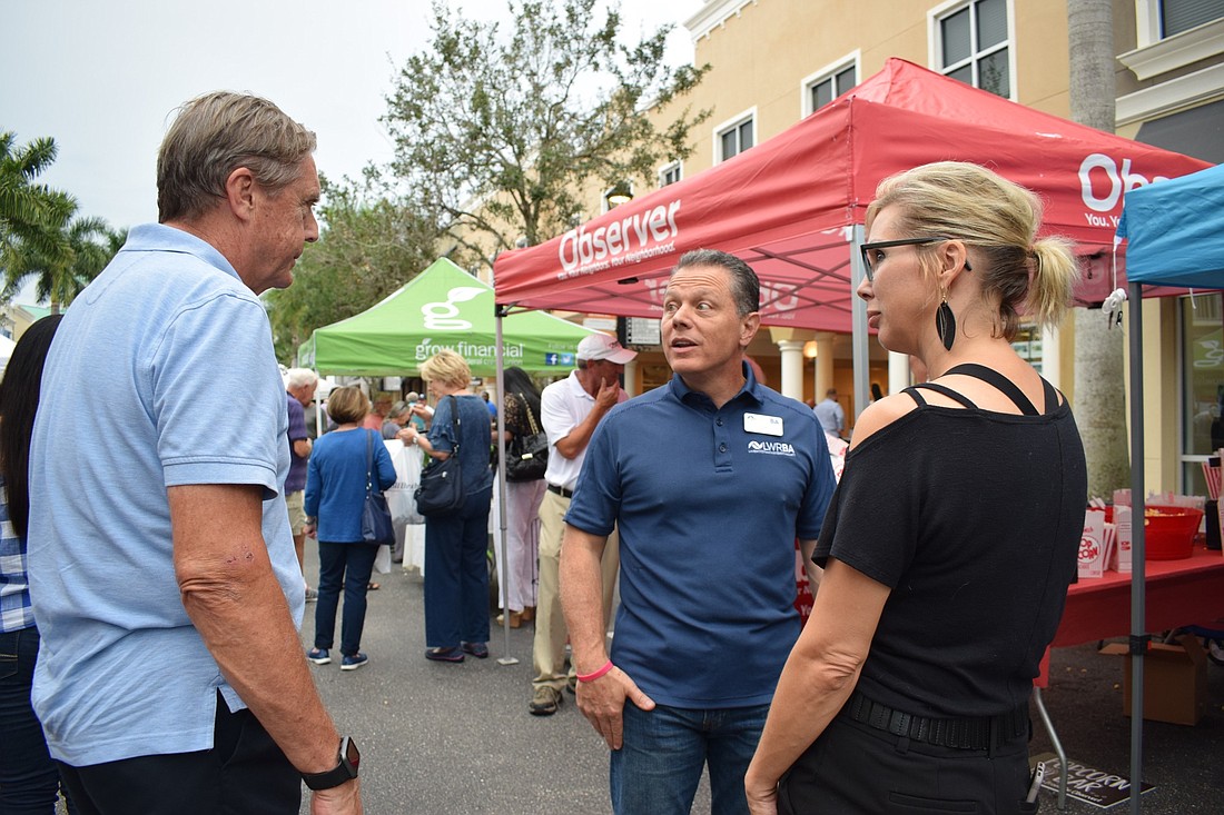 Dom DiMaio talks to Anna Clark, of Sirius Day Spa, and Ed Levins, of Village Bikes, while making his way to the different tents at the annual Lakewood Ranch Block Party and Club Day.