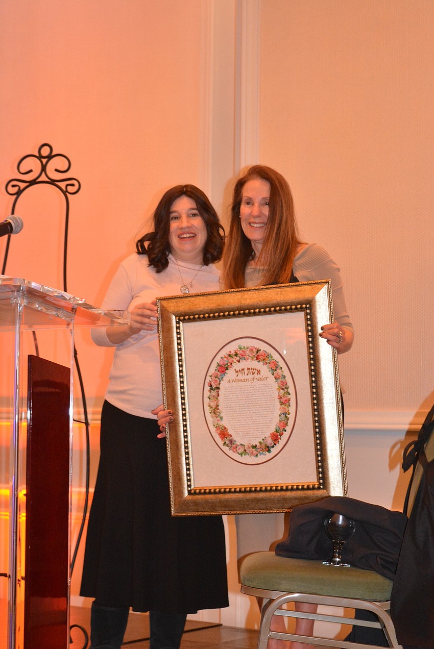 Chabad of Bradenton and Lakewood Ranch's Rabbi Chanie Bukiet honors Wendy Claussen with an award as part of the festivities.