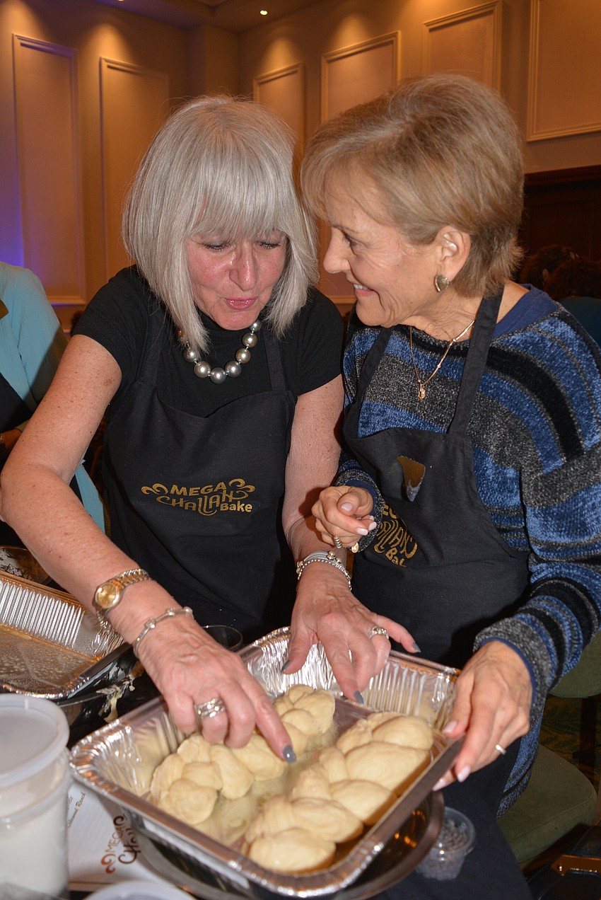 Lakewood Ranch's Sandie Ivers makes challah bread every Friday. She helps bread-making novice Shelley Goldklang braid rolls of bread.
