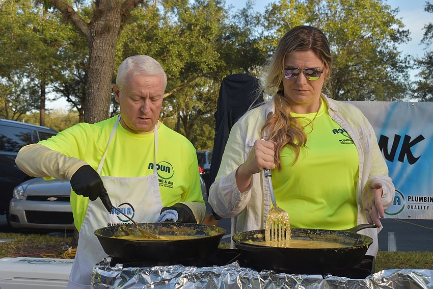 John Wojtyna and Angela Lutjens cook massive amounts of scrambled eggs.