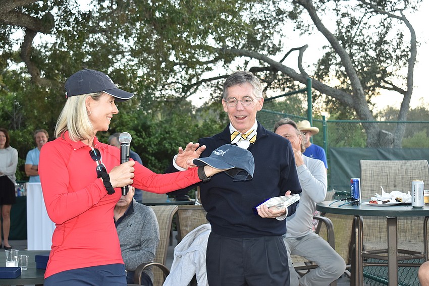 Thayer presents Walsh with tennis center merchandise.