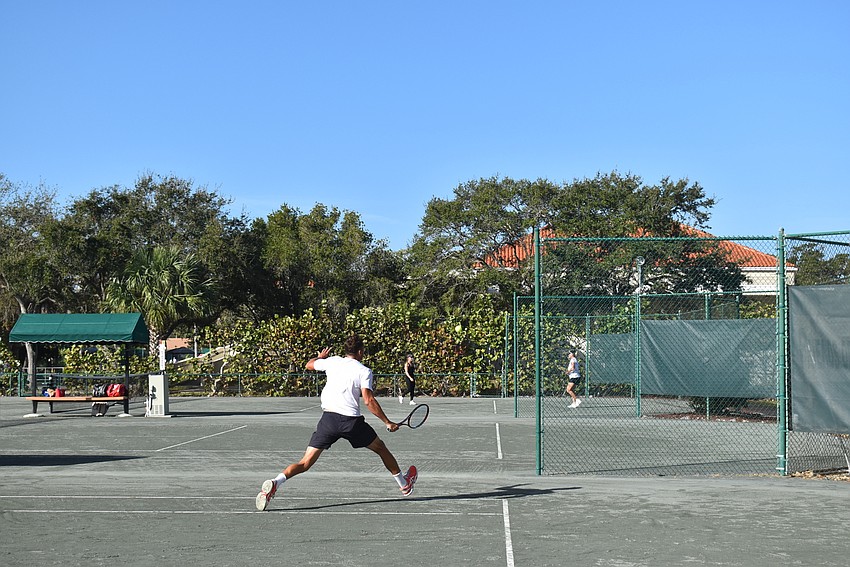 Tomasz Borucki swings for a point in a singles match.