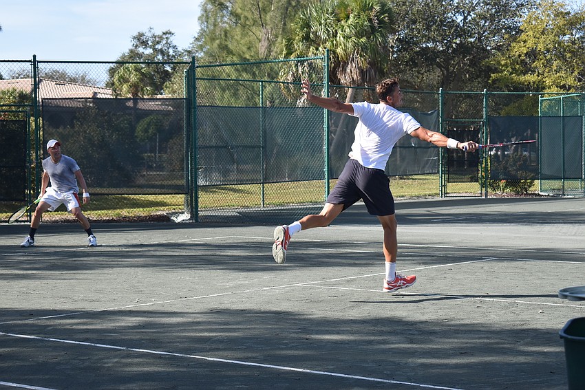 Tomasz Borucki swings for a point in a doubles match.