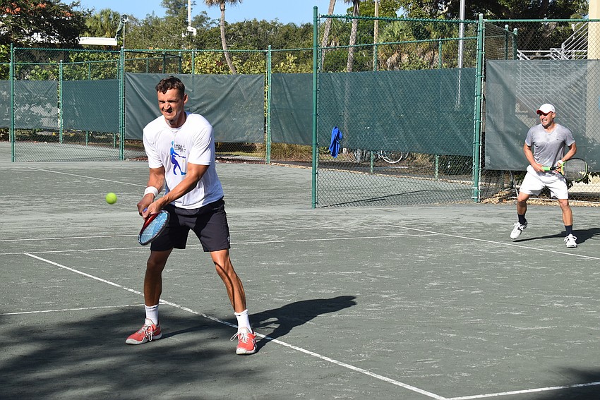 Tomasz Borucki swings for a point in a doubles match.