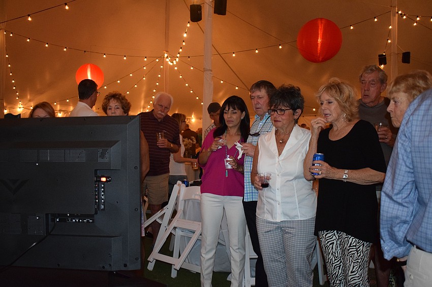 Waterlefe residents watch a slideshow of photos of residents throughout the community's 20 years.