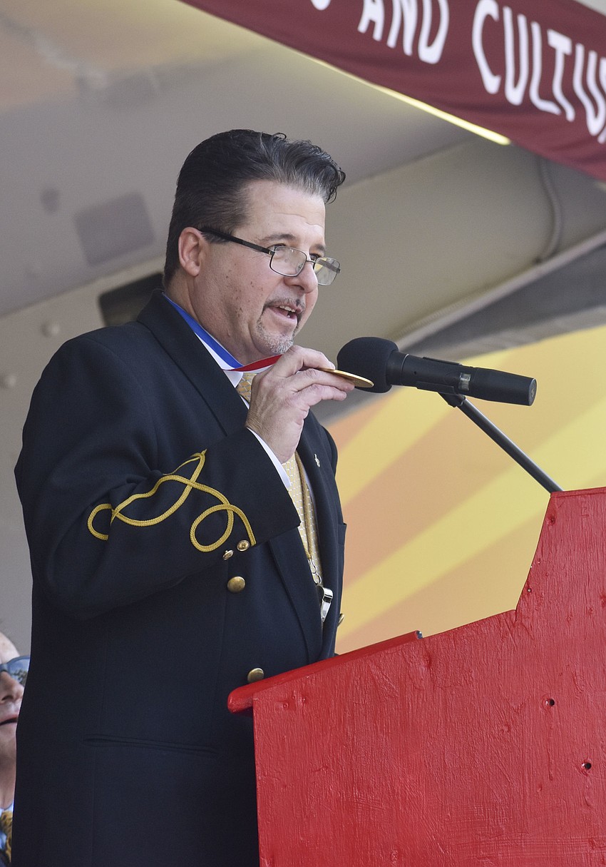 Master of Ceremonies Jospeh Domenic Bauer shows his father Joseph Bauer Sr.'s ring of fame medal.