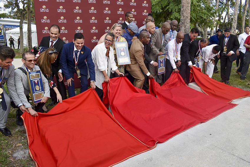 The inductees pull away the sheet to reveal their bronze plaque.